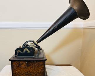 Antique Edison cylinder phonograph The phonograph features a large external horn, a hand crank, and a wooden base, likely made of oak. With records