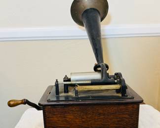 Antique Edison cylinder phonograph The phonograph features a large external horn, a hand crank, and a wooden base, likely made of oak. With records