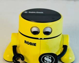 vintage 1980s Radio Shack Robie the Robotic Banker coin bank.
It functions as an electronic coin bank designed to encourage saving.
When a coin is placed on its hand and the hand is pressed down, Robie lifts its arm, "eats" the coin, and performs a
