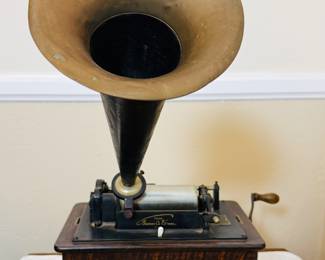 Antique Edison cylinder phonograph The phonograph features a large external horn, a hand crank, and a wooden base, likely made of oak. With records