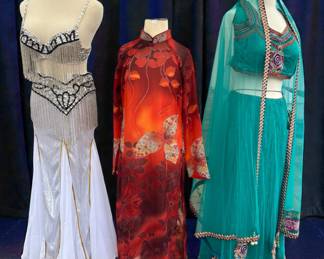 Vintage & Performance Costume Set – 3 Statement Outfits
Belly Dance • Asian-Inspired • Embellished Festival Wear
Set of three striking performance and costume outfits, each featuring bold design and stage-ready detail.
• Silver & White Belly Dance Set: Beaded bra top with fringe and coordinating skirt, high-sparkle movement for performance
• Red Asian-Inspired Long Dress: High-neck cheongsam-style silhouette with floral motifs and flowing drape
• Teal Indian-Inspired Ensemble: Embellished two-piece set with sheer overlay and ornate trim
Condition: Good vintage / costume condition
Size: Costume sizing; best fits Small–Medium
Use: Dance, stage, festival, editorial styling, or display