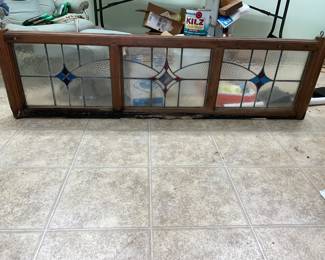 A nice piece of stained glass, but it needs the wood replaced on the bottom. This would look great over a door.