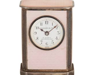241
Tiffany & Co.: A Sterling Silver and Guilloche Enamel Travel Clock
Featuring a round diamond with Arabic hour markers, signed Tiffany & Co., 8 Days Switzerland, set in a rectangular standing frame accented by panels of pink guilloche enamel, no. 128816, signed Tiffany & Co., Germany

Measures: 1 3/4 x 1 1/4 x 3/4 in.
81.2 grams gross
Estimate: $700 - $900