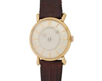 257
LeCoultre: A 14K Gold 'Mystery Dial' Watch
Dial: 30.00 mm, round with baton hour markers and diamond set round hands
Case:35.00 mm
Number: 598341 serial, 182 case
Closure: brown leather strap with a gold-plated buckle clasp
Signed: dial

Inner circumference:6 1/2 - 8 1/2 in.
26.6 grams gross
Estimate: $1,000 - $1,500