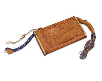 161
A Russian Karelian Birch & 18K Gold Cigarette Case
Featuring a burl-patterned Karelian birch case with hinged lid and 18k gold trim to edges, with a gold chain attachment hook, woven cord remnant, and a strike plate to one end with match compartment

Measures: 4 1/4 x 2 5/8 x 3/4 in.
56.5 grams gross
Estimate: $1,000 - $1,500