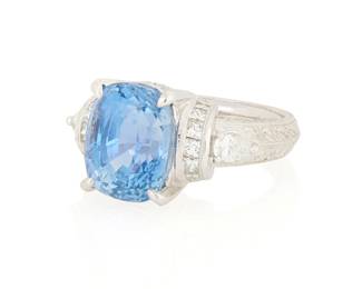 136
A Platinum, Sapphire and Diamond Ring
Featuring a modified cushion-cut sapphire weighing 9.03 carats, accented by pear-shaped, princess-cut and round diamonds all set in a foliate engraved mount

Size: 6 1/2
15.5 grams gross

Accompanied by a GRS Report numbered #031142, dated March 24, 2004, stating the Sapphire as natural Corundum of Sri Lankan origin with no enhancements.
Estimate: $12,000 - $18,000
