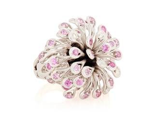 204
Christian Dior: An 18K White Gold and Pink Sapphire Ring
Of a large floral domed design featuring white gold petals accented by near colorless and pink sapphires, signed Dior, D1938, 53

Size: 6 1/2
57.8 grams gross
Estimate: $14,000 - $18,000
