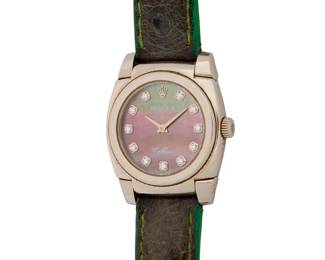 264
Rolex: An 18K White Gold and Mother-of-Pearl 'Cellini' Watch
Dial: 18.00 mm, round mother-of-pearl dial with diamond set hour markers
Model: Cellini
Case: 26.00 mm
Case number: 5310, A997143 serial
Closure: green leather strap with a gold buckle clasp
Signed: dial, case and clasp

Inner circumference: 6 1/4 - 7 1/2 in.
39.8 grams gross
Estimate: $2,000 - $3,000