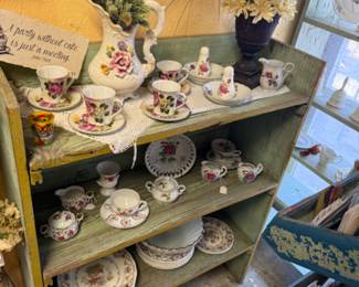 pretty green bookshelf and tea cups and saucers
