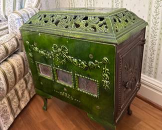 Austria/Germany, Late 1800s–Early 1900s
Beautiful cast-iron European parlor stove with deep green porcelain enamel, decorative floral relief panels, pierced latticework top, and original mica window frames. Highly collectible and rarely found in this color and condition.