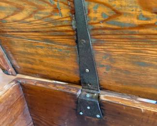 Sea chests needed strong, long hinges to withstand movement at sea.
Long blacksmith-forged straps with irregular hand-driven nails is textbook for mid–late 19th century maritime trunks.