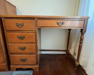 C34 - $25. Wooden Office Desk. 4 Drawers. Measures 40" wide x 17" deep x 30.5" tall. Sturdy. Heavy wear/chewing? on right front leg. 