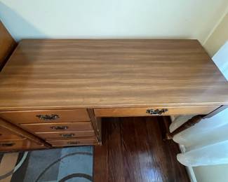 C34 - $25. Wooden Office Desk. 4 Drawers. Measures 40" wide x 17" deep x 30.5" tall. Sturdy. Heavy wear/chewing? on right front leg. 