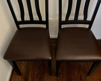 C46 - $40. PAIR of Wavy Back Dining Chairs. Black Wooden Frames with brown faux leather seat. Very good condition.Measures 18" wide x 38.5" tall. 