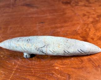 This lot features a hand-carved soapstone sculpture of an Inuit hunter and kayak. Signed underneath and measures, 6” H x 15” W x 3” D. The hunter has come detached as shown in photos and can sit just fine or be reattached.
