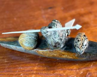 "Hunter and Kayak", an Inuit hand-carved sculpture, likely made of soapstone by listed artist, Arnold Kayutak. Signed underneath as shown in photos and measures, 4” H x 9.5” W x 4” D.
