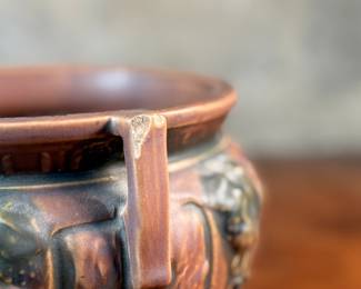 This lot features an antique jardiniere by Roseville Pottery from the "Florentine" pattern, introduced circa 1924. This specific line is known for its Arts and Crafts style, featuring a blend of simple shapes and detailed relief designs. Two small chips shown in photos and measures, 6.25” H x 9” W x 9” D.

