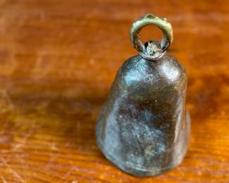 This lot features an antique African brass cattle bell that measures, 7” H x 4” W x 4” D.
