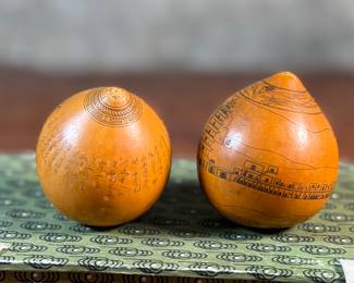 This lot features a pair of Chinese Lanzhou etched gourds displayed in a box. This type of gourd carving is a traditional folk art unique to Lanzhou, China, where carvers use fine tools to engrave landscapes, figures, and calligraphy onto the surface of the gourds. 
