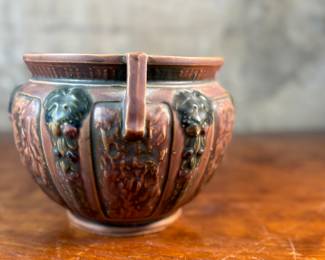 This lot features an antique jardiniere by Roseville Pottery from the "Florentine" pattern, introduced circa 1924. This specific line is known for its Arts and Crafts style, featuring a blend of simple shapes and detailed relief designs. Two small chips shown in photos and measures, 6.25” H x 9” W x 9” D.
