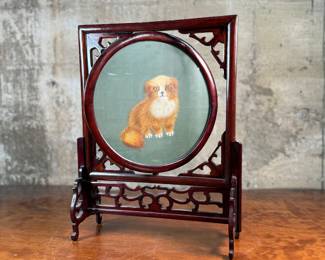 This lot features a vintage Chinese double-sided silk embroidery table screen featuring a a cat on each side, housed in a carved wooden display stand. This piece measures, 17” H x 13” W x 5” D.
