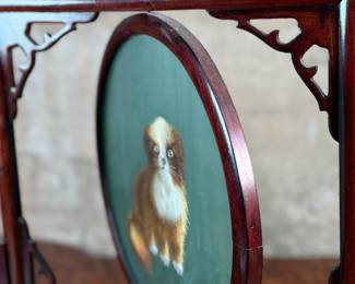 This lot features a vintage Chinese double-sided silk embroidery table screen featuring a a cat on each side, housed in a carved wooden display stand. This piece measures, 17” H x 13” W x 5” D.
