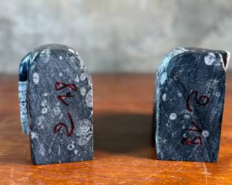 This lot features a pair of polished black marble Orthoceras fossil bookends. Each one measures, 4.5” H x 6” W x 3” D.
