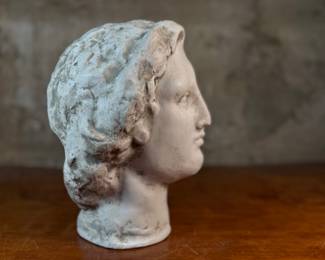 This lot features a head of a statue of Alexander the Great. Appears to be made of a heavy plaster and measures, 10.5” H x 8” W x 9” D.
