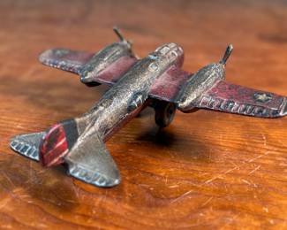 This lot features a vintage cast iron toy airplane, likely a bomber model from the World War II era. This item measures, 2.5” H x 9” W x 7” D.
