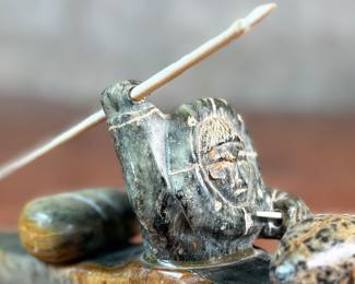 "Hunter and Kayak", an Inuit hand-carved sculpture, likely made of soapstone by listed artist, Arnold Kayutak. Signed underneath as shown in photos and measures, 4” H x 9.5” W x 4” D.
