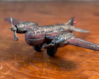 This lot features a vintage cast iron toy airplane, likely a bomber model from the World War II era. This item measures, 2.5” H x 9” W x 7” D.
