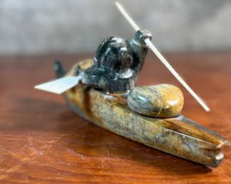 "Hunter and Kayak", an Inuit hand-carved sculpture, likely made of soapstone by listed artist, Arnold Kayutak. Signed underneath as shown in photos and measures, 4” H x 9.5” W x 4” D.
