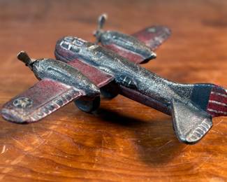 This lot features a vintage cast iron toy airplane, likely a bomber model from the World War II era. This item measures, 2.5” H x 9” W x 7” D.
