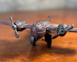 This lot features a vintage cast iron toy airplane, likely a bomber model from the World War II era. This item measures, 2.5” H x 9” W x 7” D.
