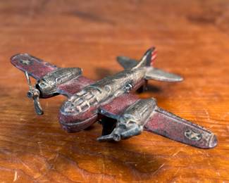 This lot features a vintage cast iron toy airplane, likely a bomber model from the World War II era. This item measures, 2.5” H x 9” W x 7” D.
