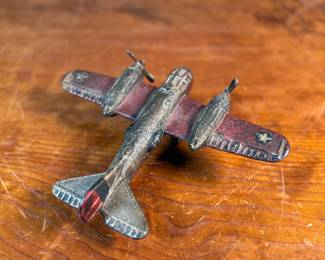 This lot features a vintage cast iron toy airplane, likely a bomber model from the World War II era. This item measures, 2.5” H x 9” W x 7” D.
