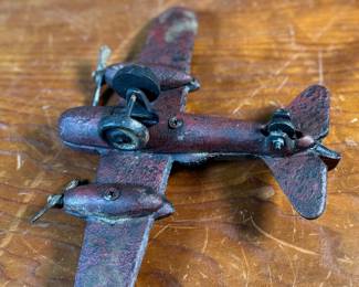 This lot features a vintage cast iron toy airplane, likely a bomber model from the World War II era. This item measures, 2.5” H x 9” W x 7” D.
