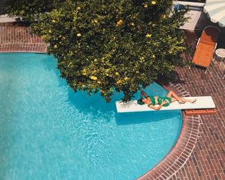 This lot features a 2022 “calendar” by Bryan Adams for Pirelli titled, “On the Road”. A unique book full of famous photographs. A collectible edition in the original slipcase. Bryan Adams is known for photographing the 2022 Pirelli Calendar, which is titled “On the Road” and features portraits of various musicians like Cher, Iggy Pop, Jennifer Hudson, and Rita Ora. Adams, a successful photographer as well as a musician, created the calendar to capture the glamour and loneliness of a musician’s life on tour.
