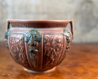This lot features an antique jardiniere by Roseville Pottery from the "Florentine" pattern, introduced circa 1924. This specific line is known for its Arts and Crafts style, featuring a blend of simple shapes and detailed relief designs. Two small chips shown in photos and measures, 6.25” H x 9” W x 9” D.

