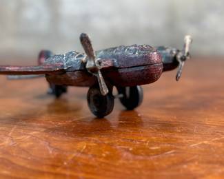 This lot features a vintage cast iron toy airplane, likely a bomber model from the World War II era. This item measures, 2.5” H x 9” W x 7” D.

