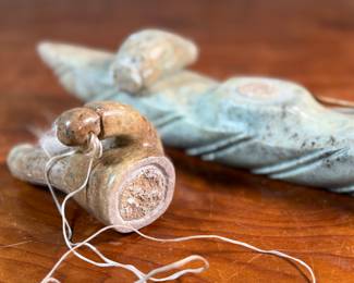This lot features a hand-carved soapstone sculpture of an Inuit hunter and kayak. Signed underneath and measures, 6” H x 15” W x 3” D. The hunter has come detached as shown in photos and can sit just fine or be reattached.
