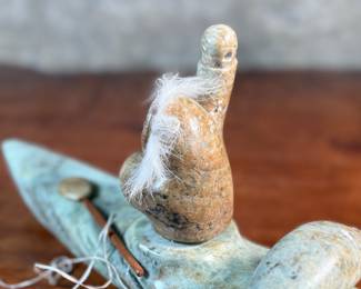 This lot features a hand-carved soapstone sculpture of an Inuit hunter and kayak. Signed underneath and measures, 6” H x 15” W x 3” D. The hunter has come detached as shown in photos and can sit just fine or be reattached.
