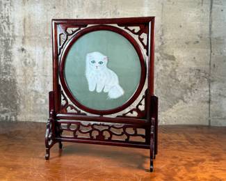 This lot features a vintage Chinese double-sided silk embroidery table screen featuring a a cat on each side, housed in a carved wooden display stand. This piece measures, 17” H x 13” W x 5” D.
