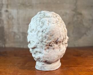 This lot features a head of a statue of Alexander the Great. Appears to be made of a heavy plaster and measures, 10.5” H x 8” W x 9” D.
