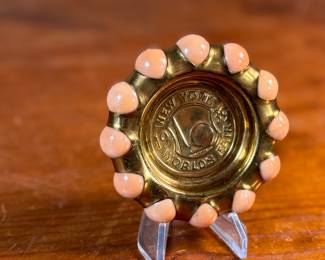 This lot features a Fisher Jewel Tray commemorating the 1939 New York World’s Fair. The tray is made of hammered brass with a ring of coral-colored vitro agate marbles around the outer circumference. These small trays were originally designed to hold ladies’ jewelry. 
