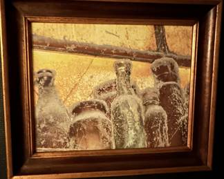 Framed print of frosted glass bottles from Patricia Pinto's 'Serie Vino' collection.