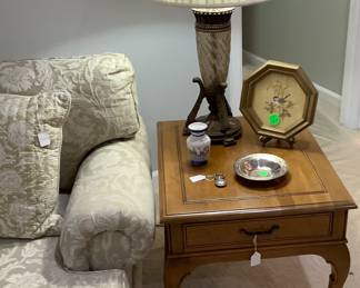 Solid oak wood end table with drawer by club chair.