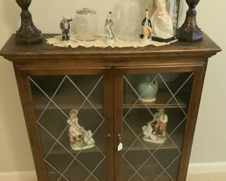 Small cabinet with glass doors and wood shelves.