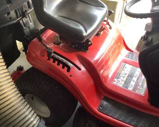 The riding lawn mower in garage, it is Troy-Bill, 7 speed. Has grass catcher, also has a grass thatcher included. Like new. Price: $900.00 with attachments.
