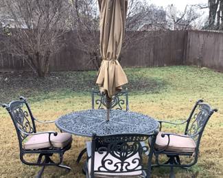 Round metal table with 4 matching chairs with cushions. Has an umbrella in center and chairs rock. Price js: $180.00 with umbrella.